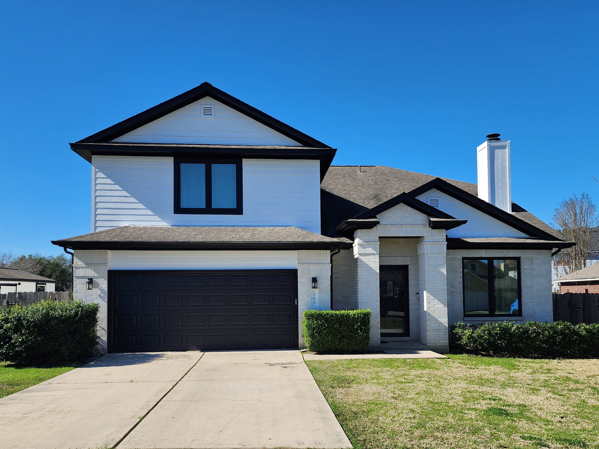 The same home with new black-framed replacement windows