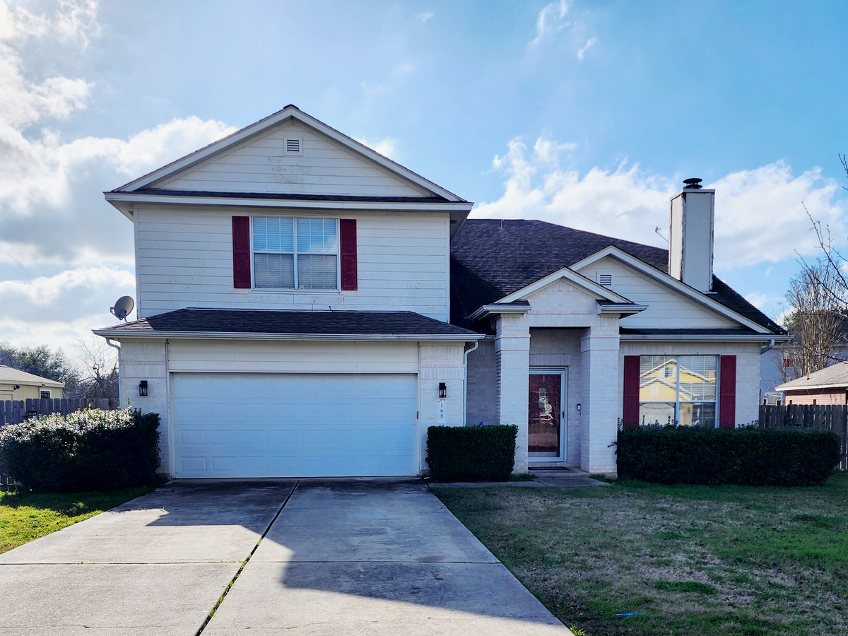 Front of the home with white windows before replacement